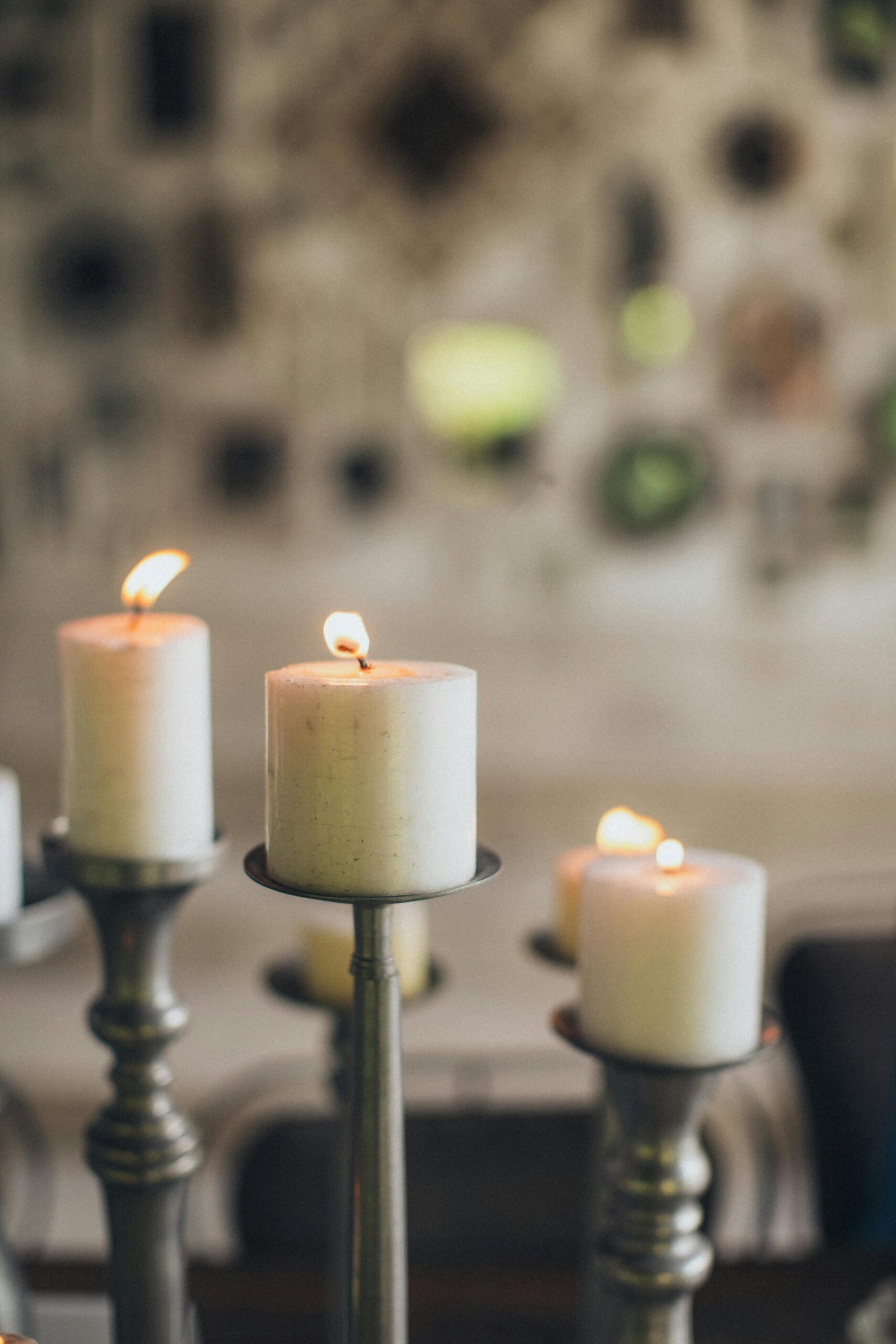 Warm candlelight setting with white candles on holders. Perfect for cozy ambiances.